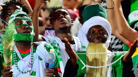 Getty Images A Nigeria supporter cheers during the 2019 Africa Cup of Nations (CAN) quarter final football match between Nigeria and South Africa at Cairo international stadium on July 9, 2019.