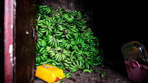 Getty Images Bananas are stored in a storage at the area of Atikilt Tera, in Addis Ababa on July 2, 2019. - Global demand for agricultural products is projected to grow by 15 percent over the coming decade, while agricultural productivity growth is expected to increase slightly faster, causing inflation-adjusted prices of the major agricultural commodities to remain at or below their current levels, according to an annual report by the Organisation for Economic Co-operation and Development 5OECD) and the UN's Food and Agriculture Organization (FAO).
