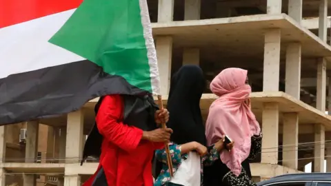 Getty Images Sudanese protestors celebrate in the streets of Khartoum after ruling generals and protest leaders announced they have reached an agreement on the disputed issue of a new governing body on July 5, 2019. - The landmark agreement came after two days of talks following the collapse of the previous round of negotiations in May over who should lead the new ruling body -- a civilian or soldier. "The two sides agreed on establishing a sovereign council with a rotating military and civilian (presidency) for a period of three years or little more," African Union mediator Mohamed El Hacen Lebatt told reporters.