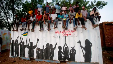 Getty Images Sudanese protestors celebrate in the streets of Khartoum after ruling generals and protest leaders announced they have reached an agreement on the disputed issue of a new governing body on July 5, 2019. - The landmark agreement came after two days of talks following the collapse of the previous round of negotiations in May over who should lead the new ruling body -- a civilian or soldier. "The two sides agreed on establishing a sovereign council with a rotating military and civilian (presidency) for a period of three years or little more," African Union mediator Mohamed El Hacen Lebatt told reporters.