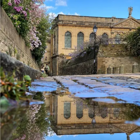 Esther Johnson Reflection in a puddle on Queen's Lane in Oxford