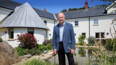 Les Bourgs Hospice Jake Honeybill standing in the gardens of Les Bourgs Hospice