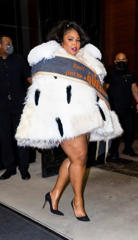 Gotham, GC Images, Getty Lizzo wearing a faux ermine dress with a sash which is embroidered with the words: 'Don't be a drag, be a queen' by Viktor & Rolf (New York, 2021).