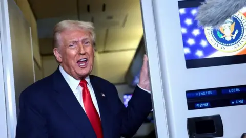 Reuters US President Donald Trump speaks to members of the media on board Air Force One en route to the US